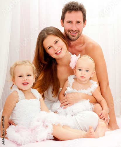 Photo: Happy young family. Indoors. Happy young family. Indoors.