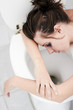 A young woman passed out on the toilet bowl