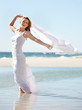 Beautiful blonde holding a white scarf behind her to blow in the