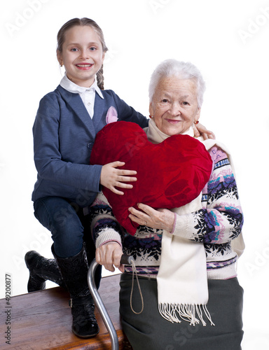 Photo: Grandmother with granddaughter holding heart pillow Grandmother with granddaughter holding heart pillow