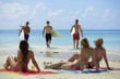 Photo: Surfers walking up the beach while watched by some bikini-clad w Surfers walking up the beach while watched by some bikini-clad w