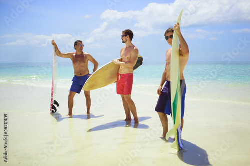 Photo: Surfers holding their boards and preparing to go in Surfers holding their boards and preparing to go in