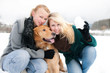 zwei junge Frauen mit Hund im Schnee
