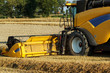 Yellov combine on field harvesting gold wheat