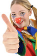 Junge Frau im Clown-Kostüm "Daumen rauf"