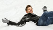 Young man lies on back on snow
