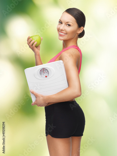 Photo: woman with apple and weight scale woman with apple and weight scale