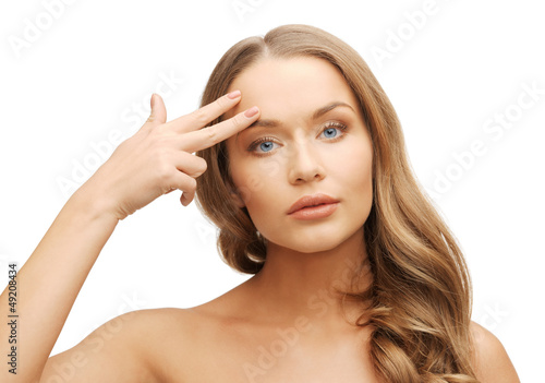 Photo: beautiful woman pointing to forehead beautiful woman pointing to forehead