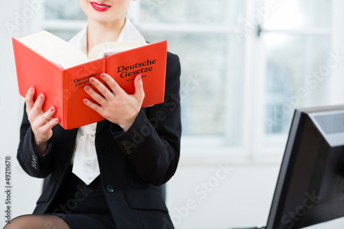 Photo: Anwältin in Kanzlei liest im Gesetzbuch Anwältin in Kanzlei liest im Gesetzbuch