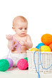 Baby plays with colored balls of yarn
