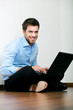 Young man sitting on the floor with his laptop