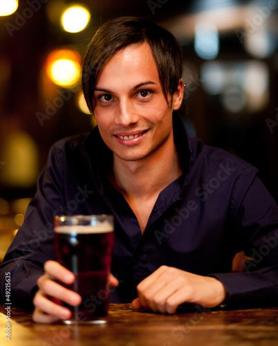 Photo: Man drinking a beer in a pub Man drinking a beer in a pub