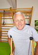 Senior mit Krücken in Turnhalle