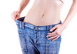 woman shows her weight loss by wearing an old jeans