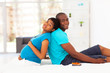 pregnant african american woman and husband sitting on bed