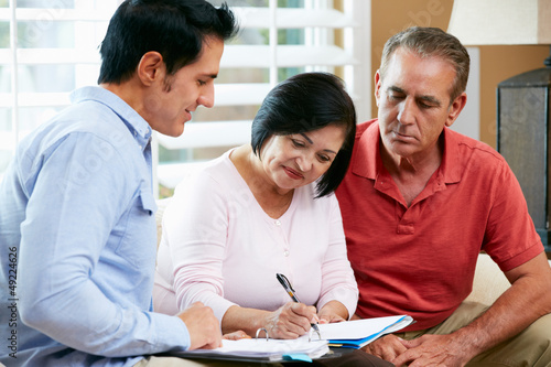 Photo: Financial Advisor Talking To Senior Couple At Home Financial Advisor Talking To Senior Couple At Home