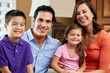 Portrait Of Family Sitting On Sofa At Home
