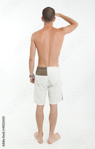 Photo: Rear view of man in swimming trunks looking far Rear view of man in swimming trunks looking far