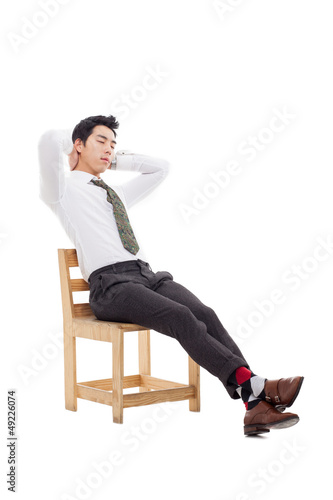 Photo: Young Asian business man sitting on the chair and fall a sleep. Young Asian business man sitting on the chair and fall a sleep.