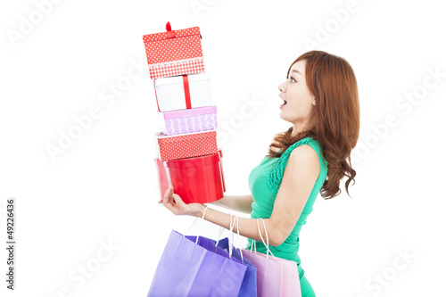 Photo: surprised young woman holding gift box and shopping bag surprised young woman holding gift box and shopping bag