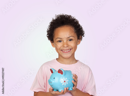 Photo: Happy latin child with a blue moneybox Happy latin child with a blue moneybox