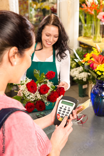 Photo: Woman florist selling flowers customer paying card Woman florist selling flowers customer paying card