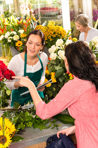 Photo: Young florist ordering roses woman customer flower Young florist ordering roses woman customer flower