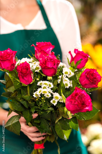 Photo: Florist woman holding red roses bouquet hands Florist woman holding red roses bouquet hands