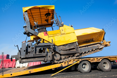 Photo: Transportation tracked paver machine during roadworks Transportation tracked paver machine during roadworks