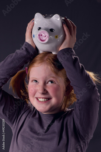 Photo: Mädchen mit Sparschwein auf dem Kopf Mädchen mit Sparschwein auf dem Kopf