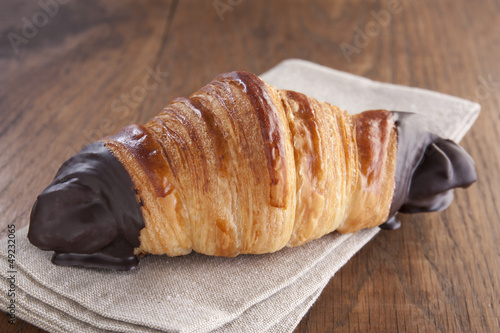 Photo: Chocolate croissant on rustic table Chocolate croissant on rustic table