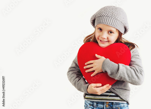 Photo: Young girl with red heart on white background. Young girl with red heart on white background.