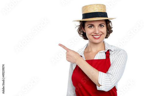 Photo: Cute woman in hat pointing sideways Cute woman in hat pointing sideways
