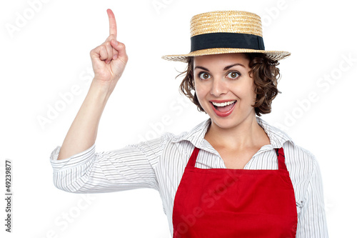 Photo: Excited chef woman pointing upwards Excited chef woman pointing upwards