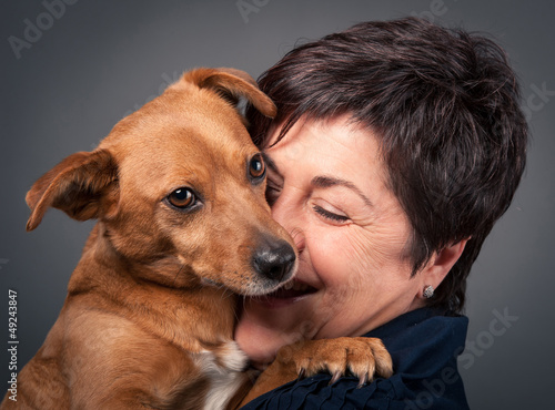Photo: Small dog and middle age woman. Small dog and middle age woman.
