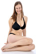 Junge Frau in schwarzem Bikini sitzt