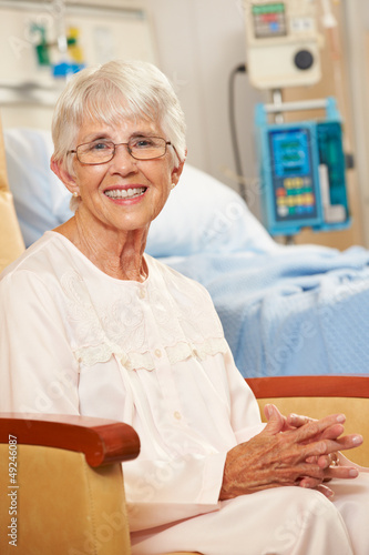 Photo: Portrait Of Senior Female Patient In Chair By Hospital Bed Portrait Of Senior Female Patient In Chair By Hospital Bed