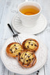 Sweet cakes with cup of tea on white table