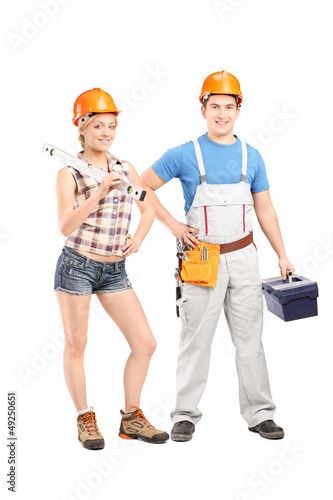 Photo: Team of a male and female construction workers holding tools Team of a male and female construction workers holding tools