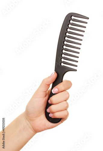 Photo: Black comb in female hand isolated on white Black comb in female hand isolated on white