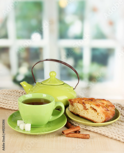 Photo: cup of tea with scarf on table in room cup of tea with scarf on table in room