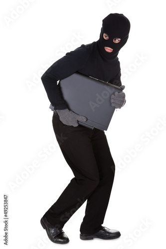 Photo: Thief stealing a laptop computer Thief stealing a laptop computer