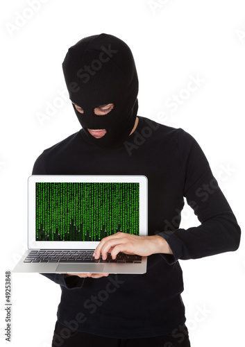 Photo: Hacker stealing data from a laptop Hacker stealing data from a laptop