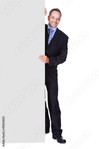 Photo: Happy Businessman Holding Blank Billboard Happy Businessman Holding Blank Billboard