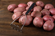 old potato masher with red potatoes