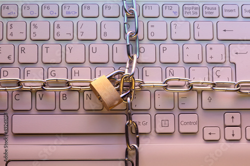 Photo: Laptop keyboard locked with a padlock. Computer security concept Laptop keyboard locked with a padlock. Computer security concept