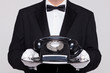 Butler holding a telephone on silver tray