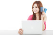 beautiful young woman holding credit card with laptop