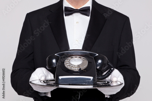 Photo: Butler holding a telephone on silver tray Butler holding a telephone on silver tray