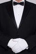 Photo: Man in a tuxedo wearing white gloves. Man in a tuxedo wearing white gloves.